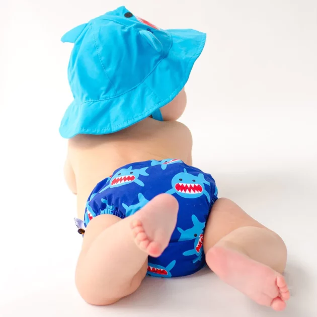 Set baby costumino contenitivo e cappellino a tema squalo indossato da un bambino