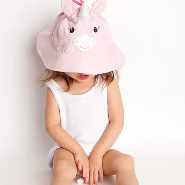 bambina che indossa cappellino estivo a forma di unicorno del marchio zoocchini