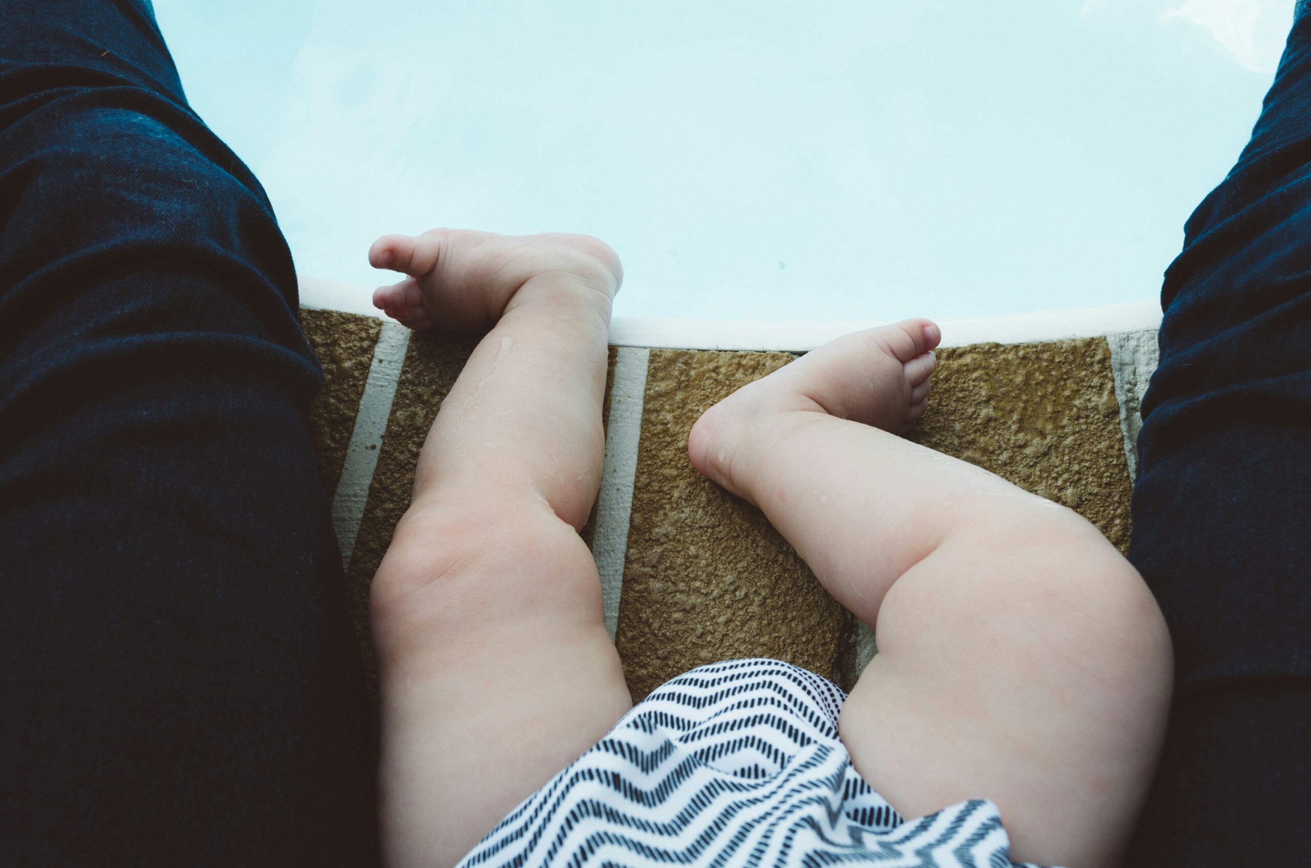 piedini e gambe di bambini con costume da bagno vicino a piscina