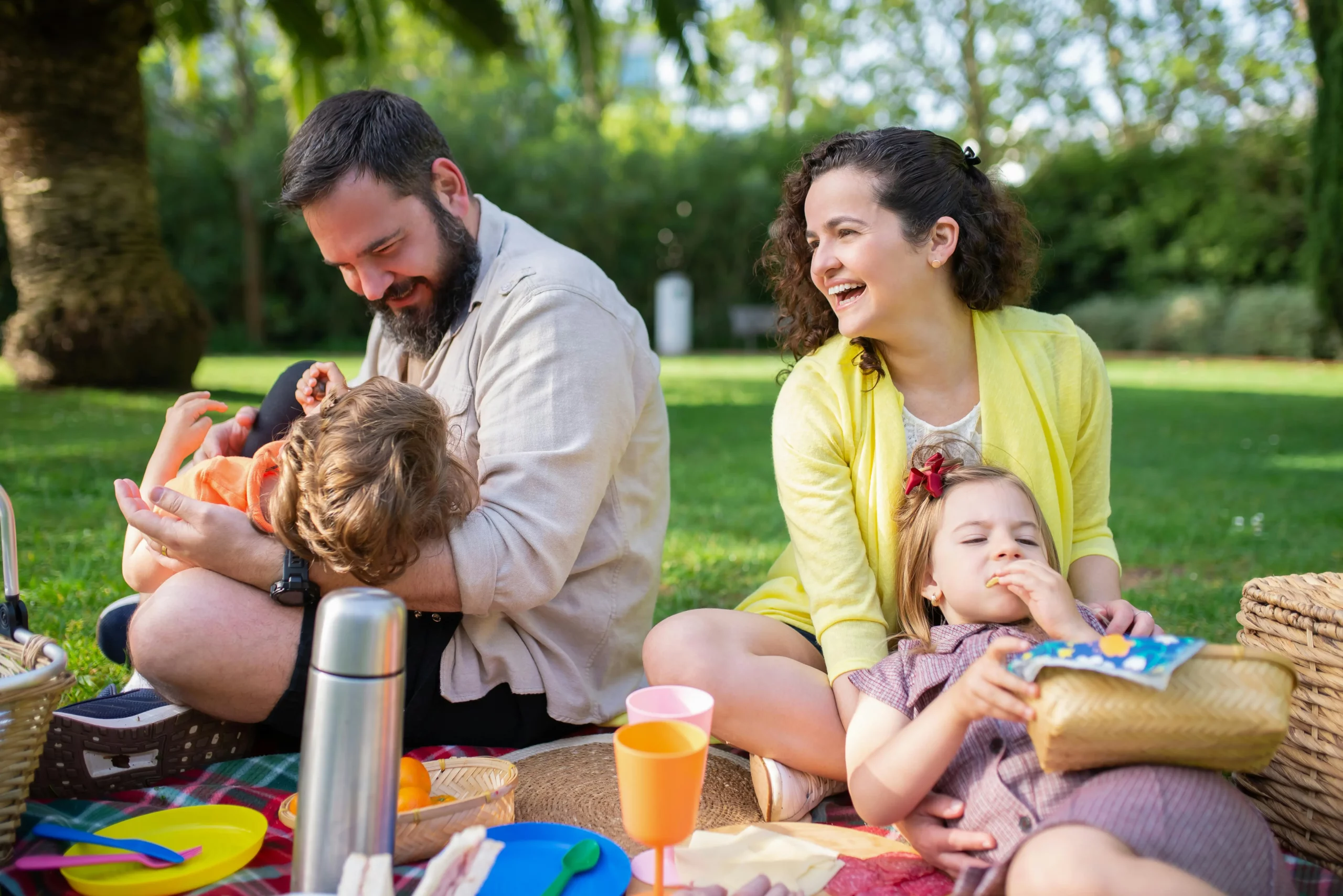 famiglia con bambini che fa picnic in un parco