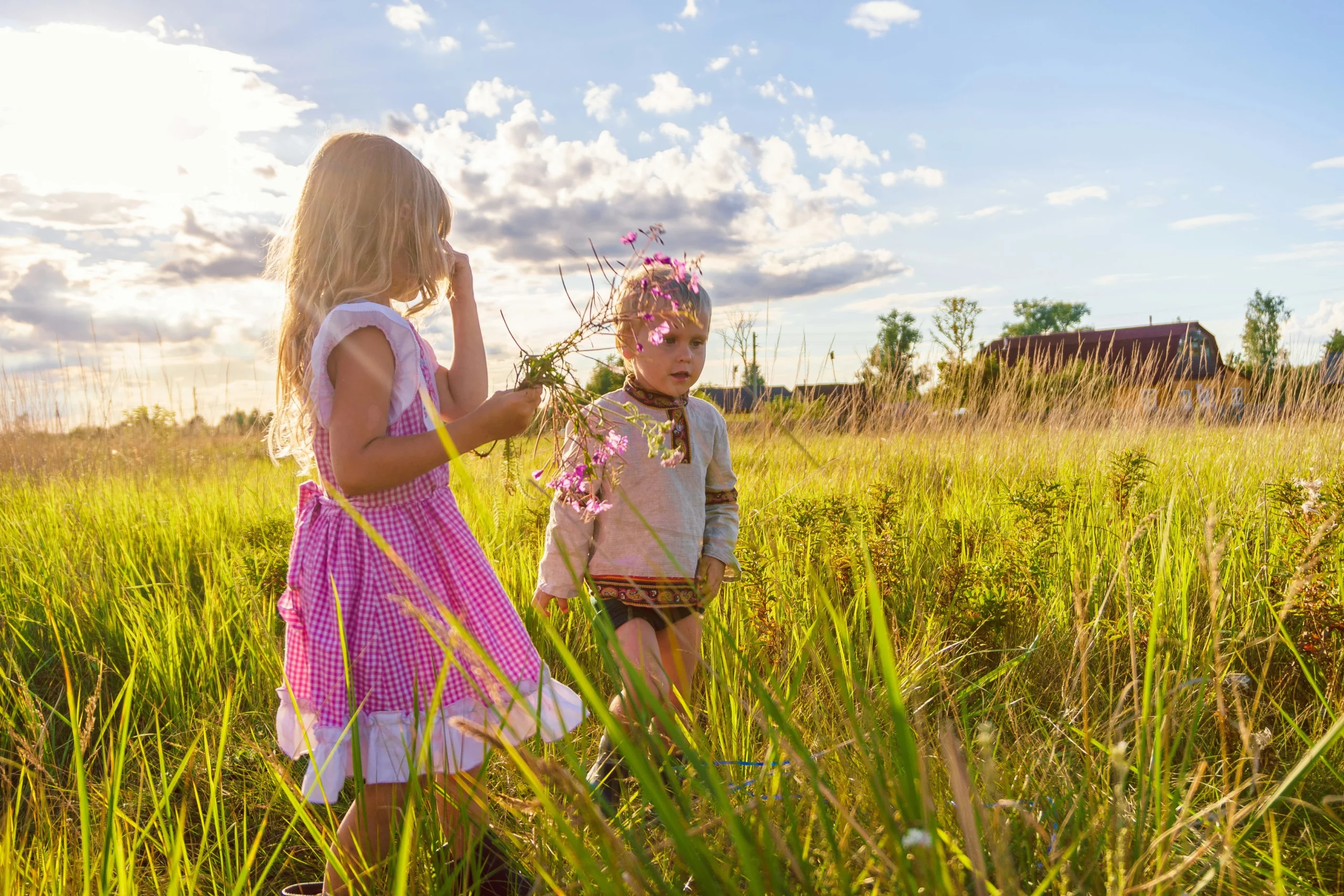 Bambina e bambino in un campo in primavera che fanno attività all'aria aperta